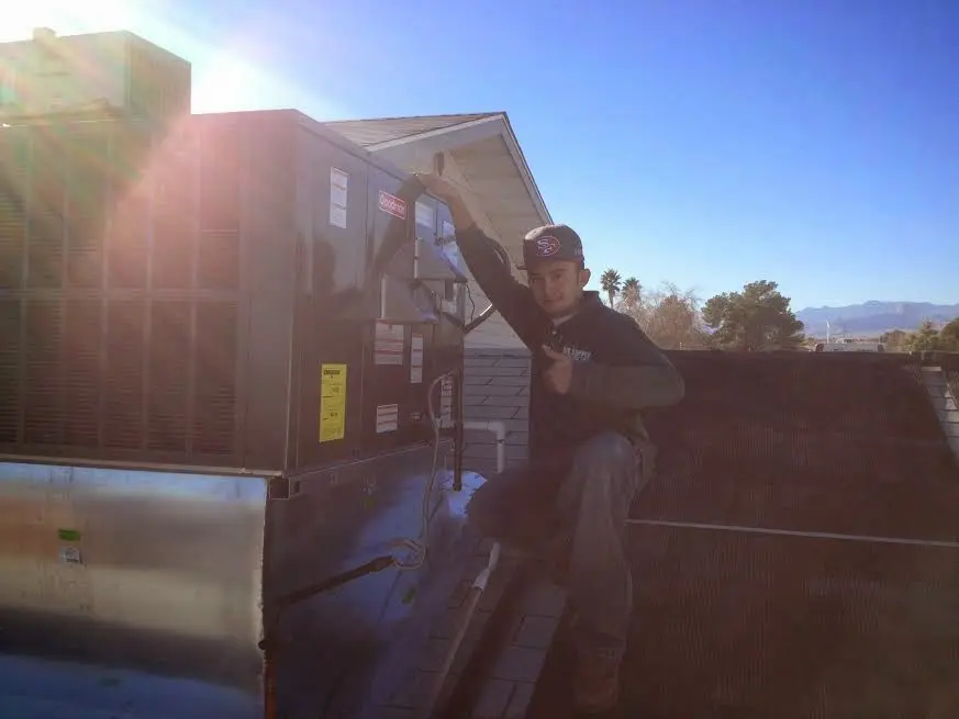 HVAC technician performing Heat Pump Repair on a rooftop unit in Cadillac